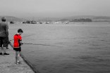 Procesión marítima y niño pescando